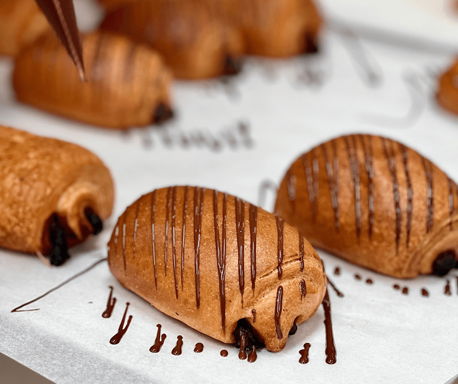 A white plate featuring a cooked steak drizzled with vibrant green sauce.