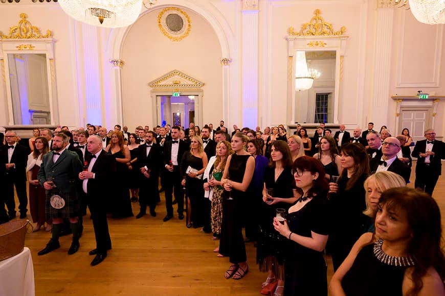 A crowd of people dressed in evening wear at an event in the Music Room