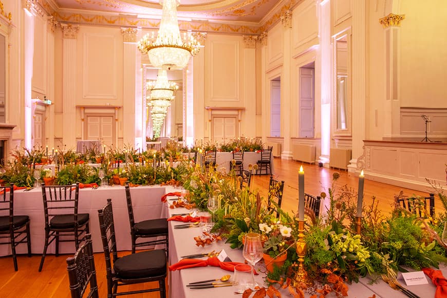 Tables laid out with green leaves and candles