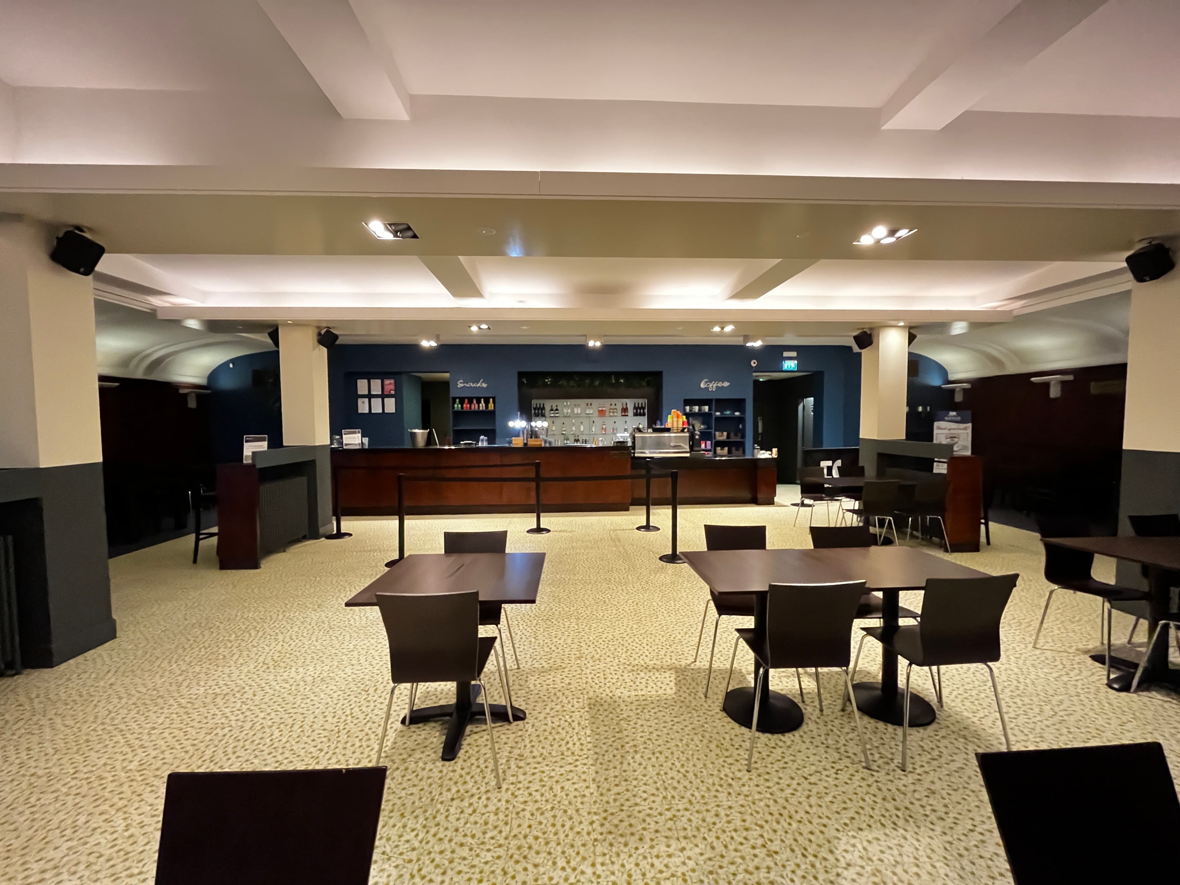 A large room featuring several tables and chairs, suitable for events or group activities.