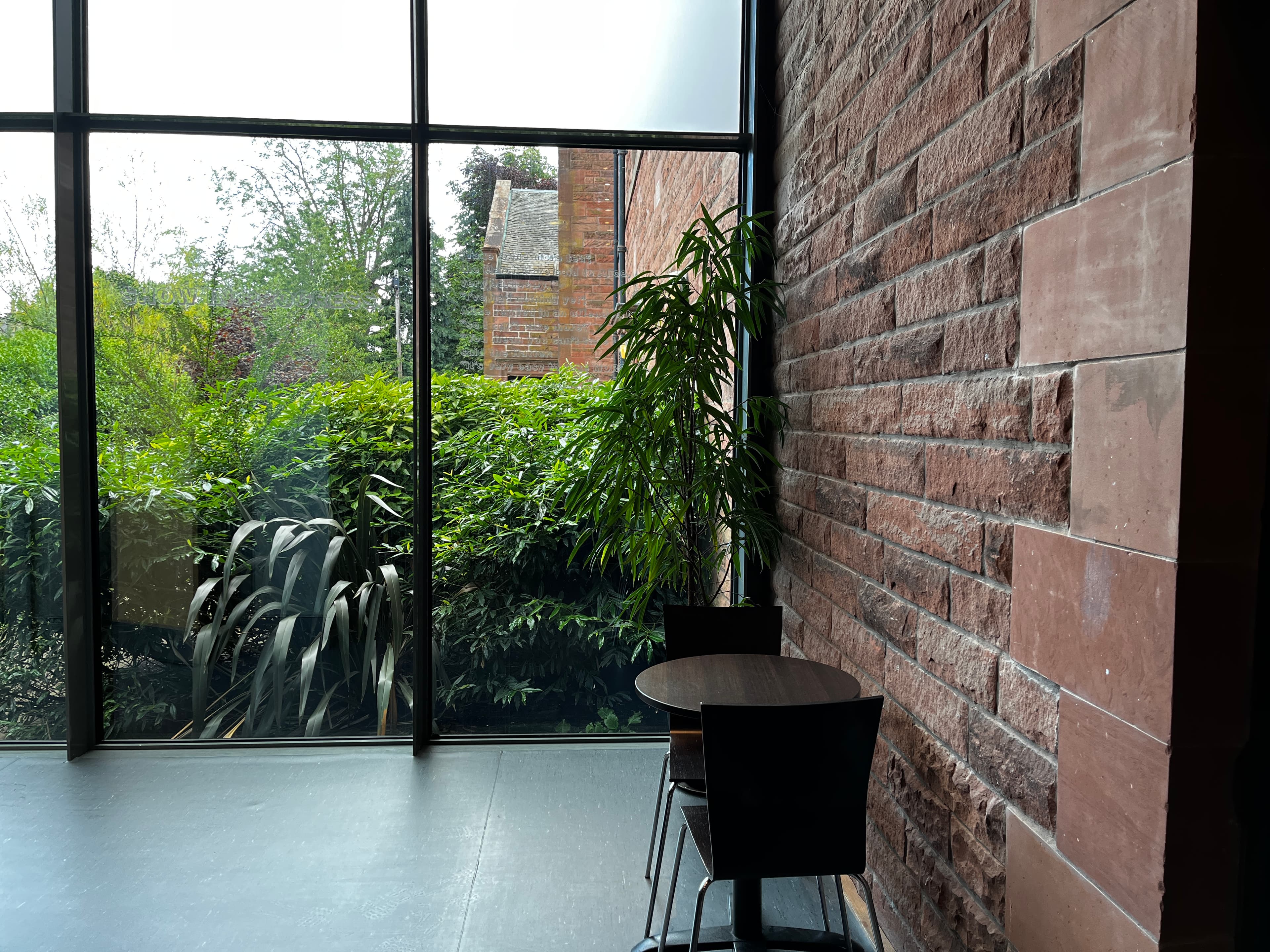 A table with chairs arranged in front of a window, creating a welcoming atmosphere filled with natural light.