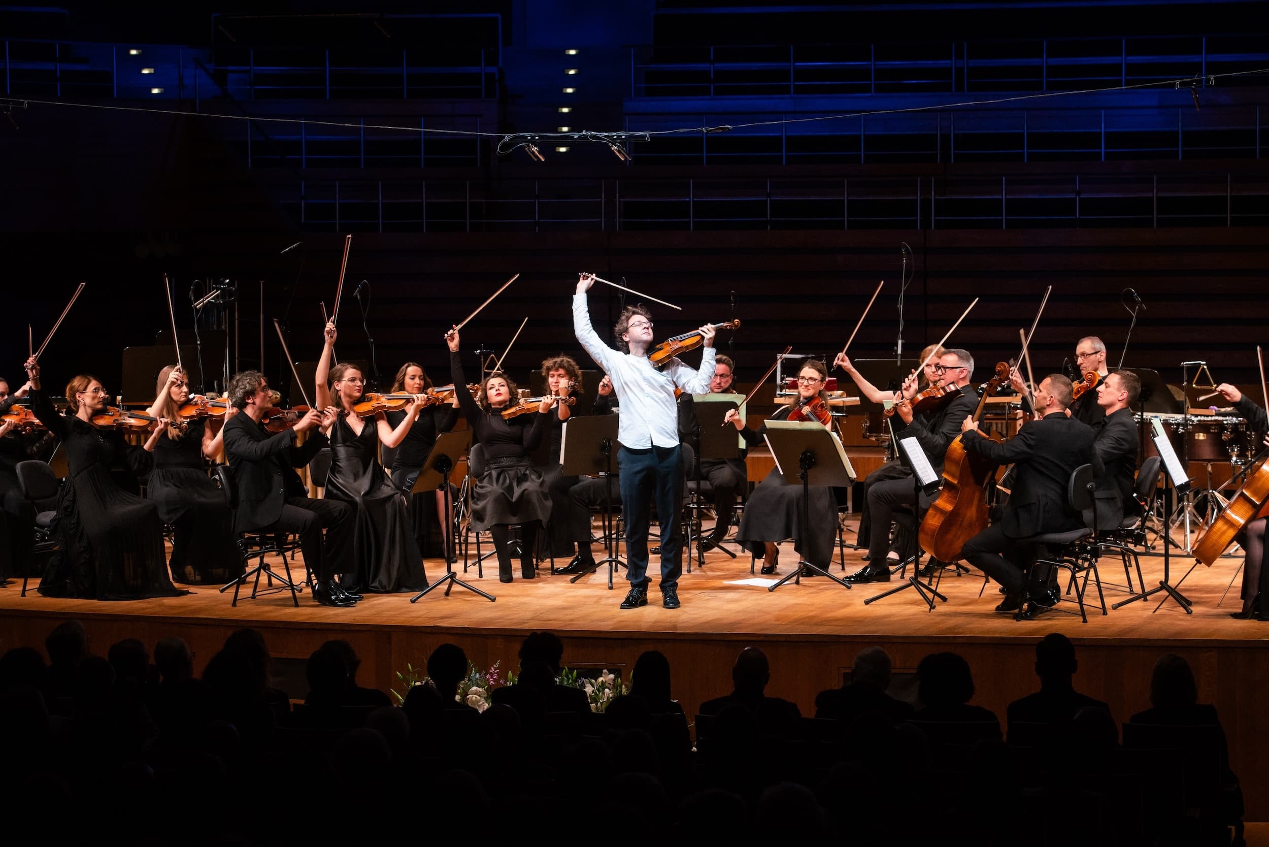 NFM Leopoldinum holding up their violin bows on stage.