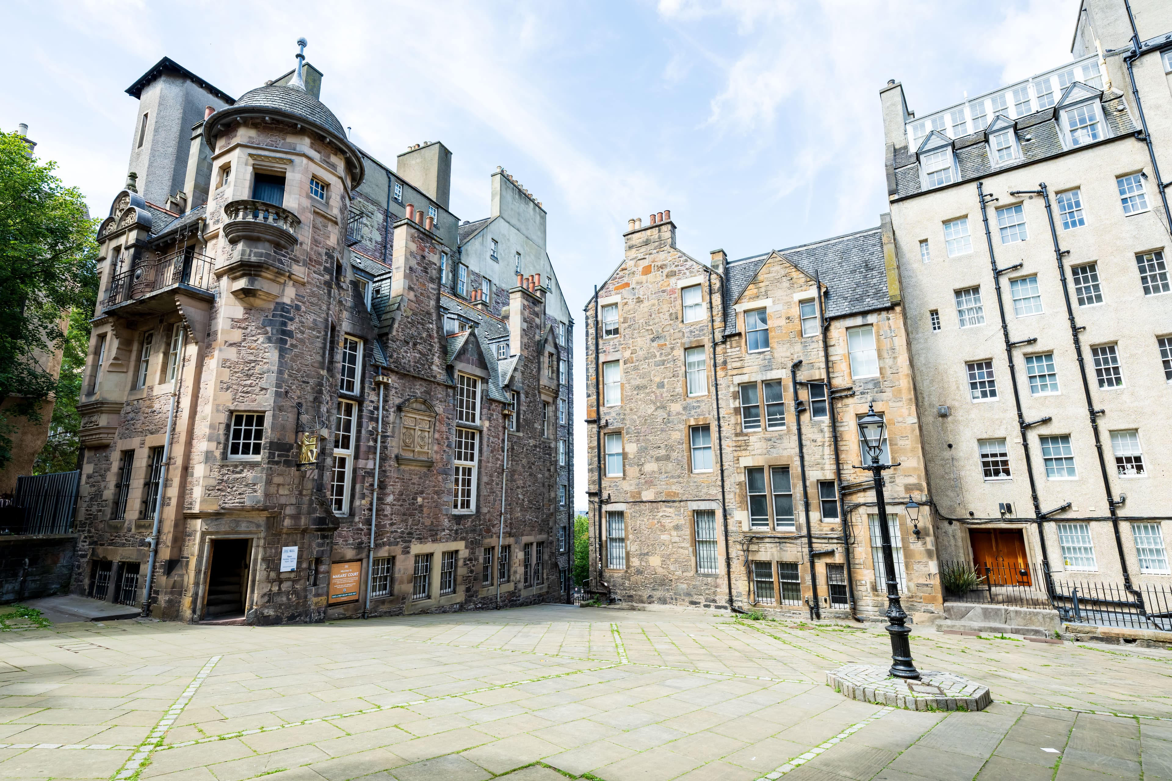 An imposing building sitting within a large courtyard. Other buildings surround the courtyard.