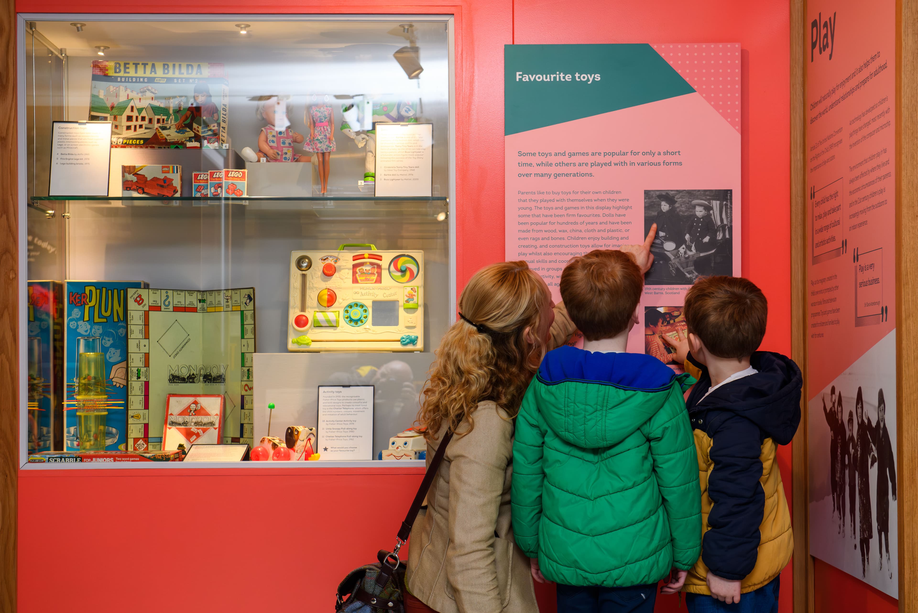 Several children gathered around a vibrant toy display, eagerly pointing and discussing their favorite items.