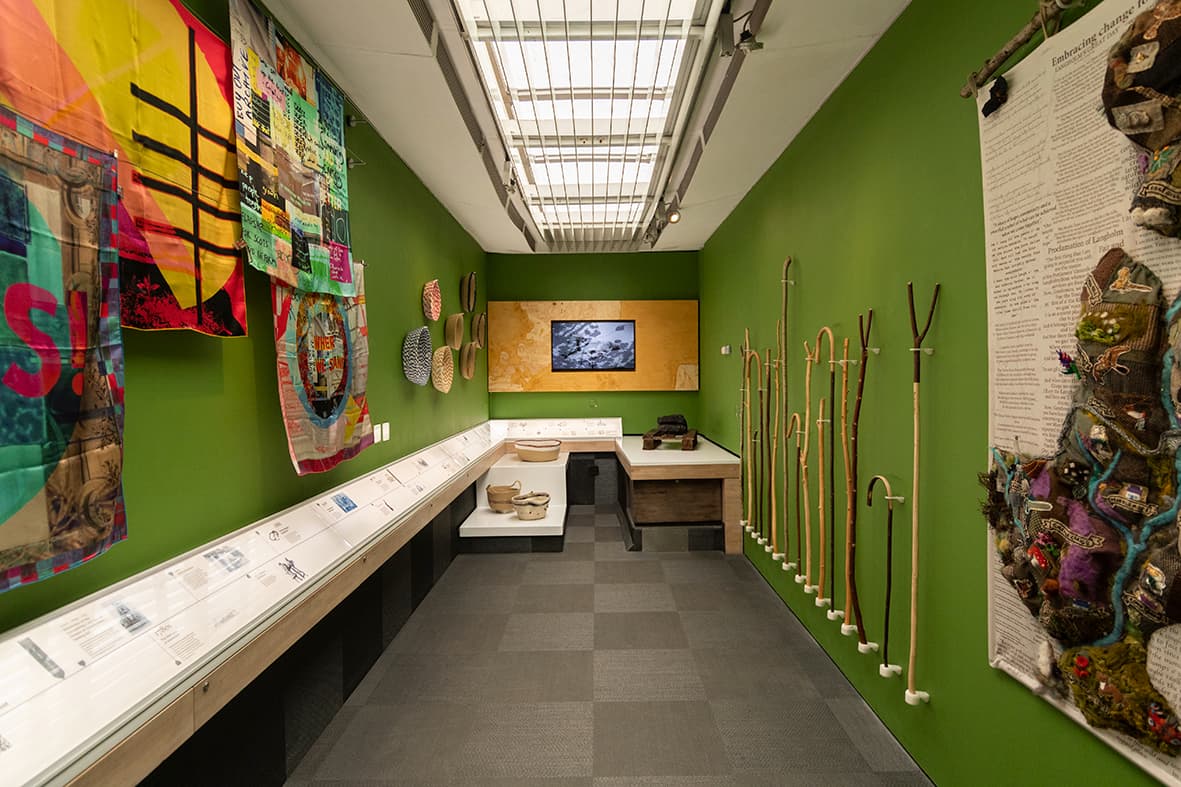 Bus interior featuring a vibrant green wall adorned with various pieces of art.