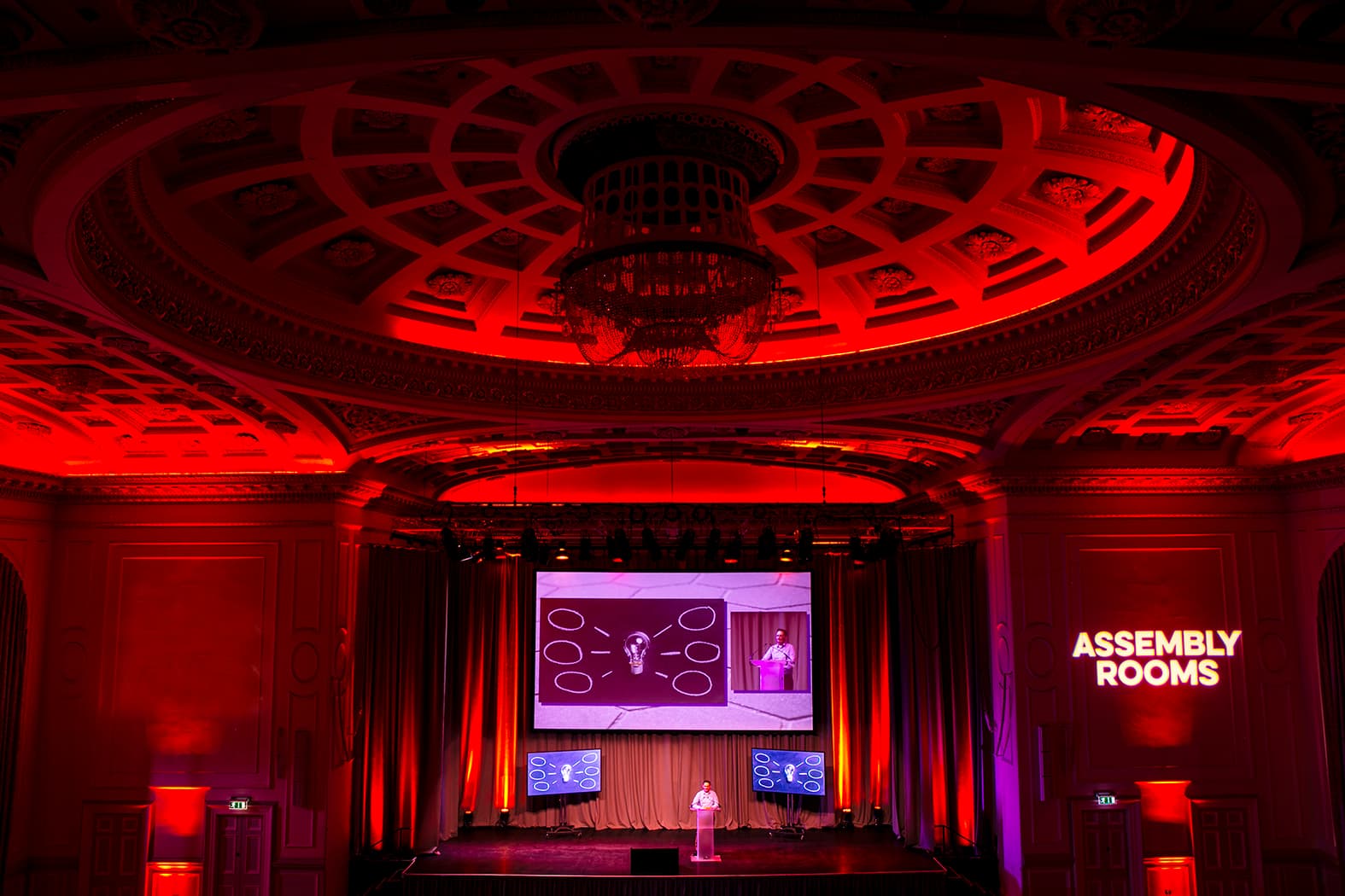 A presentation stage with a large projector screen and a podium, ready for speakers and audience engagement.