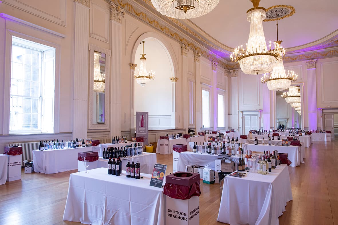 A large room featuring tables and chairs, prepared for a sophisticated wine tasting experience.