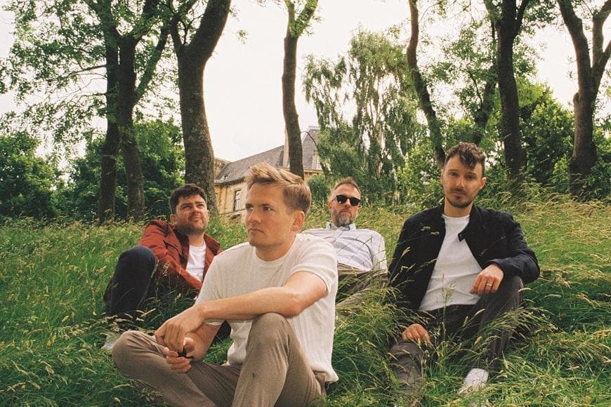 Members of Tide Lines sitting on grass