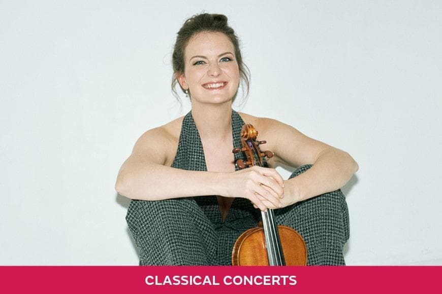 Photo of Veronika Eberle smiling whilst holding her Violin
