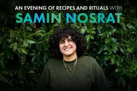 Samin Nosrat standing in from of a large hedge