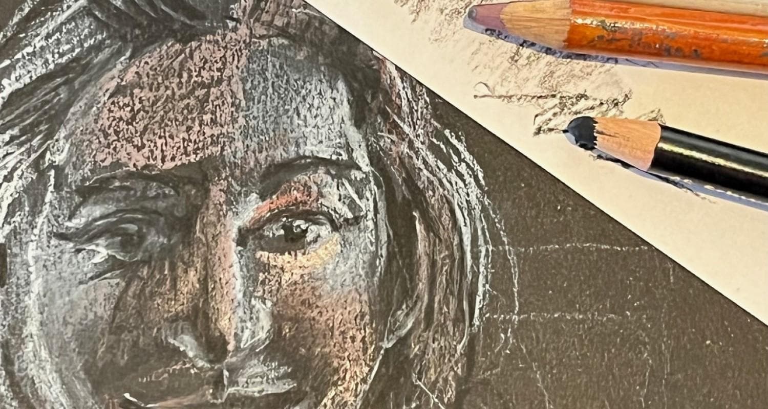 A drawing of a portrait using soft pastels on a black background. Two pencils are in the background.