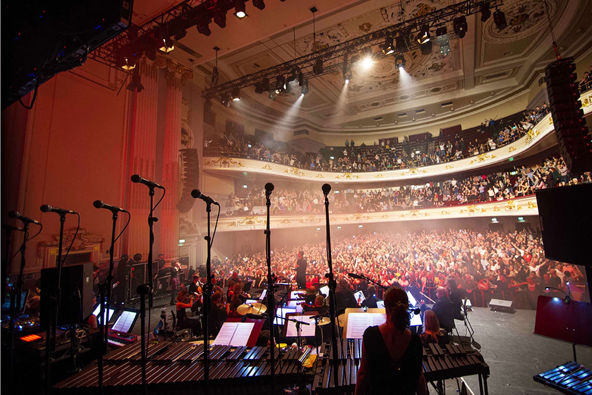 A large auditorium with a well-equipped stage and an orchestra area, designed for live performances.