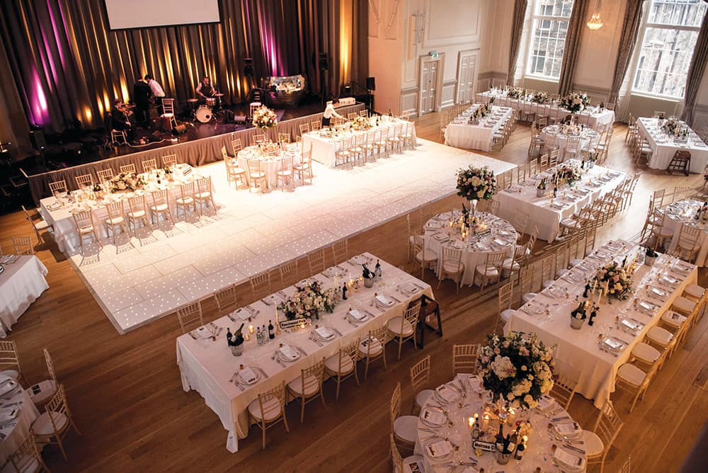 A large wedding reception venue featuring multiple tables and chairs set up for guests to gather and celebrate.